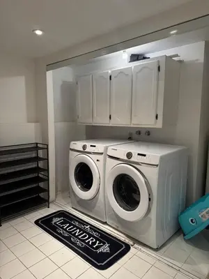 a laundry room with a washer and dryer in it at Entire Urban Cabin Retreat 3BD Terrace&Covered Parking in Terrebonne