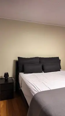 a bedroom with a large bed with white sheets at Entire Urban Cabin Retreat 3BD Terrace&Covered Parking in Terrebonne