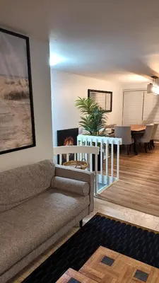 a living room with a couch and a dining room at Entire Urban Cabin Retreat 3BD Terrace&Covered Parking in Terrebonne