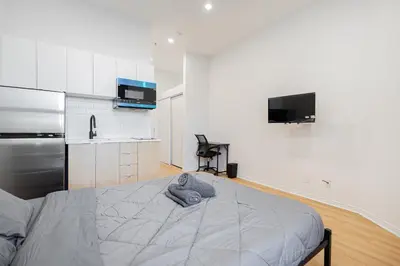 a bedroom with a bed and a kitchen at Affordable Weekly Studio For 2 Guest with Free Parking in Montréal