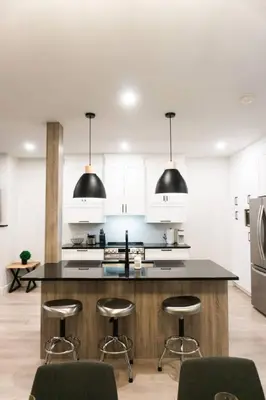 a kitchen with a large island with bar stools at Lynx spa detente Orford in Magog-Orford