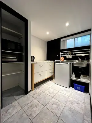 a kitchen with a white refrigerator and a sink at Charmant petit studio à 15 minutes de Montréal in Longueuil