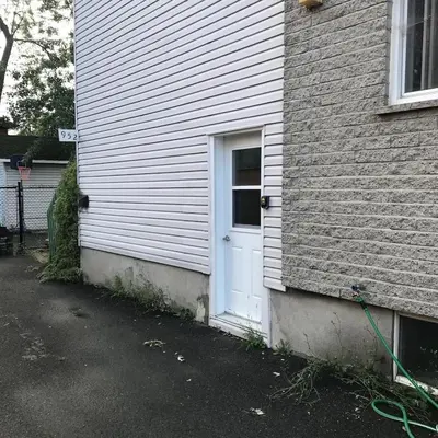 a white door on the side of a house at Charmant petit studio à 15 minutes de Montréal in Longueuil