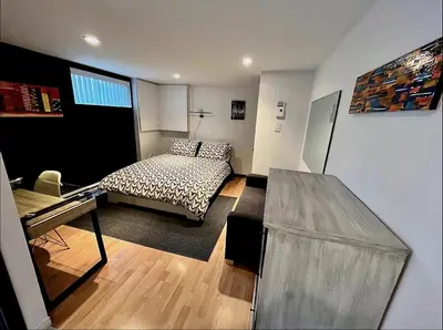 a bedroom with a bed and a desk in it at Charmant petit studio à 15 minutes de Montréal in Longueuil
