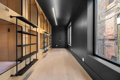 a long hallway with shelves and a window at Capsule Residence in Montréal