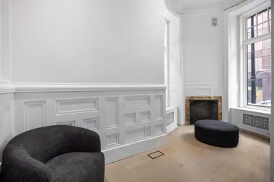 a living room with a chair and a fireplace at Capsule Residence in Montréal