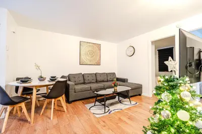 a living room with a couch and a christmas tree at Griffintown Central 2BR in Montréal