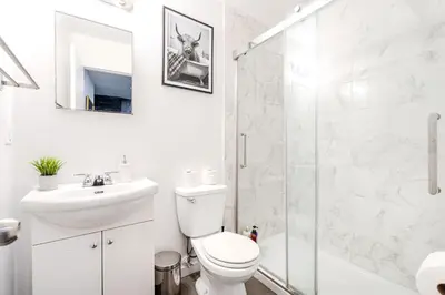 a bathroom with a toilet and a sink and a shower at Griffintown Central 2BR in Montréal