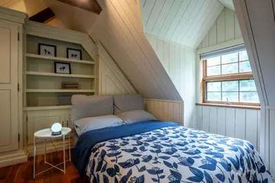 a bed with a blue and white comforter in a room at Lakefront - Quai 948 in Saint Sebastien