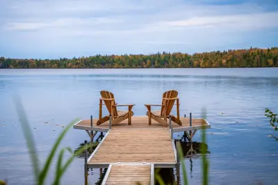 two chairs sitting on a dock on a lake at Lakefront - Quai 948 in Saint Sebastien