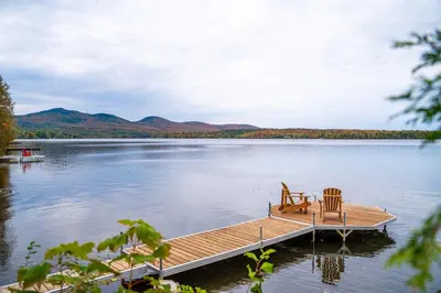 a dock on a lake with two chairs on it at Lakefront - Quai 948 in Saint Sebastien
