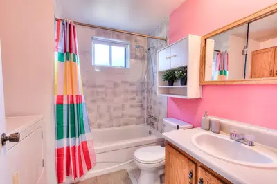 a bathroom with a rainbow shower curtain and a sink at Beautiful Spacious Apartments! 6 guest Vacation home Montreal in Montréal