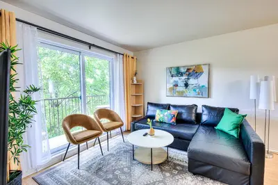 a living room with a black leather couch and a table at Beautiful Spacious Apartments! 6 guest Vacation home Montreal in Montréal