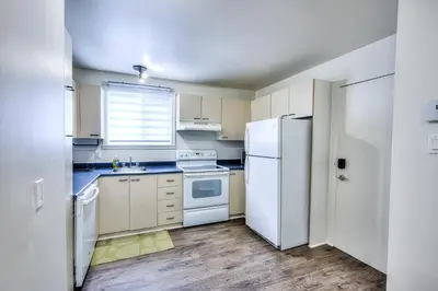 a kitchen with white appliances and a white refrigerator at Beautiful Spacious Apartments! 6 guest Vacation home Montreal in Montréal