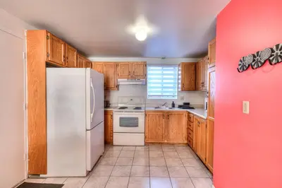 a kitchen with wooden cabinets and a white refrigerator at Beautiful Spacious Apartments! 6 guest Vacation home Montreal in Montréal