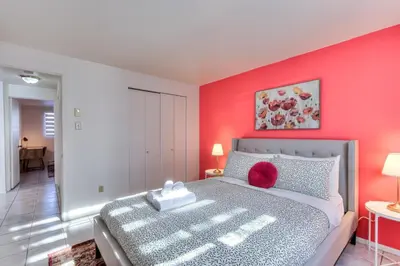 a bedroom with a bed with a red wall at Beautiful Spacious Apartments! 6 guest Vacation home Montreal in Montréal