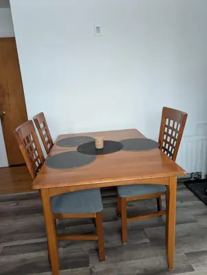 a wooden table with two chairs and a table at Belle chambre 2 pas Hôpital UQTR Services in Trois-Rivières