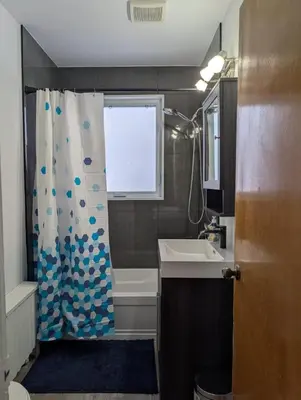 a bathroom with a shower curtain and a sink at Belle chambre 2 pas Hôpital UQTR Services in Trois-Rivières