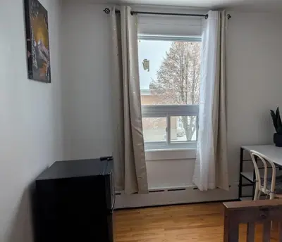 a room with a window and a table and a desk at Belle chambre 2 pas Hôpital UQTR Services in Trois-Rivières
