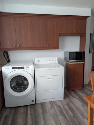 a kitchen with a washing machine and a microwave at Chambre privée 5 min Université Hôpital in Trois-Rivières