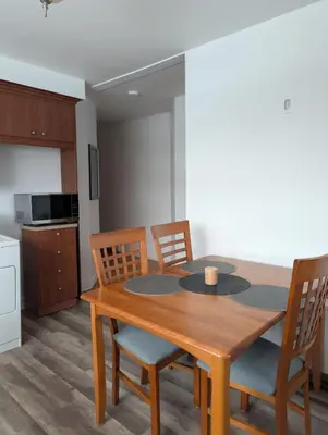 a dining room table with chairs and a kitchen at Chambre privée 5 min Université Hôpital in Trois-Rivières
