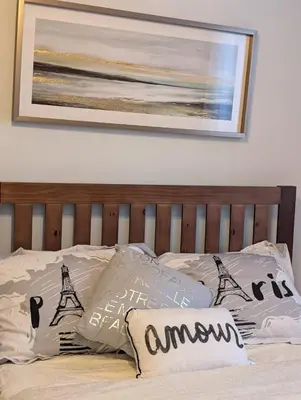 a bed with a wooden headboard with pillows on it at Chambre confortable 2 pas Hôpital Université Services in Trois-Rivières