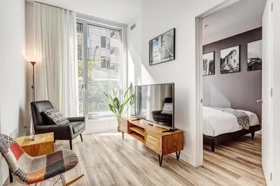 a bedroom with a bed and a television and a chair at Montreal - Stanbrooke Galaxie - 1BR 1302 in Montréal