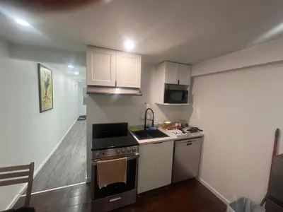 a small kitchen with a stove and a sink at Cute and Cozy Studio with Private Parking in Montréal