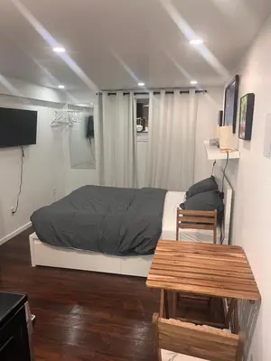 a bedroom with a bed and a wooden table at Cute and Cozy Studio with Private Parking in Montréal