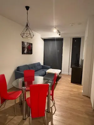 a living room with a blue couch and red chairs at Dreamzsuite in Montréal