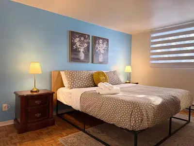 a bedroom with a bed with two lamps and a window at Free Parking! Fast Wifi! Comfortable Apt for Montreal Explorers & Adventure! in Montréal