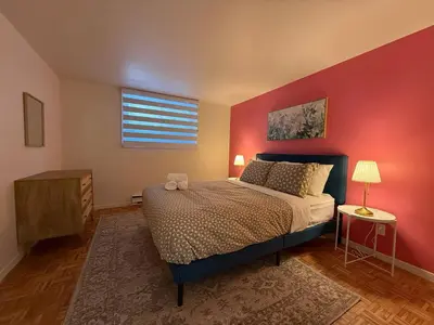 a bedroom with a bed and a red wall at Free Parking! Fast Wifi! Comfortable Apt for Montreal Explorers & Adventure! in Montréal