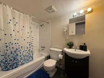 a bathroom with a toilet and a sink and a bath tub at Free Parking! Fast Wifi! Comfortable Apt for Montreal Explorers & Adventure! in Montréal