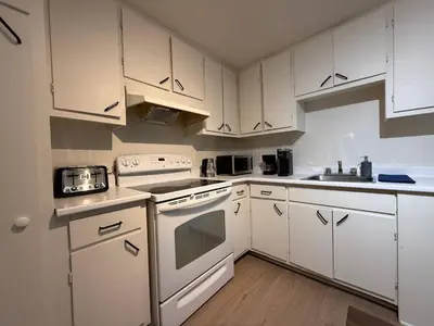 a white kitchen with white appliances and white cabinets at Free Parking! Fast Wifi! Comfortable Apt for Montreal Explorers & Adventure! in Montréal