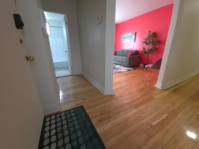 a living room with a couch and a pink wall at Special Stays! Ultimate Destination for Montreal & West Island with Fast Wi-Fi in Montréal