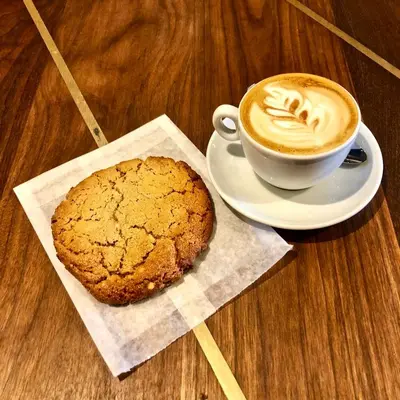 a cup of coffee and a cookie on a table at Special Stays! Ultimate Destination for Montreal & West Island with Fast Wi-Fi in Montréal