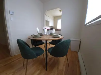 a dining room table with green chairs in a room at Special Stays! Ultimate Destination for Montreal & West Island with Fast Wi-Fi in Montréal