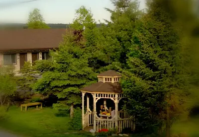 a gazebo in the yard of a house at Motel Alexandrin in Saint-Georges