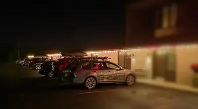 a row of cars parked in a parking lot at night at Motel Alexandrin in Saint-Georges