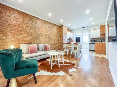 a living room with a couch and a brick wall at Upscale 2BR Retreat - Parking - 2 Queen Suites in Montréal