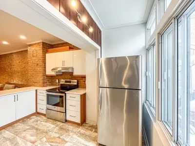 a kitchen with a stainless steel refrigerator at Upscale 2BR Retreat - Parking - 2 Queen Suites in Montréal