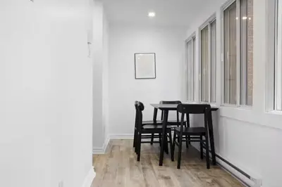 a dining room table with black chairs and a window at Modern 2BR Haven - Prime Location in Montréal