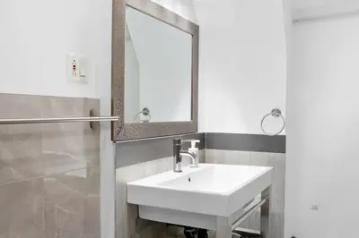 a bathroom with a white sink and a mirror at Modern 2BR Haven - Prime Location in Montréal
