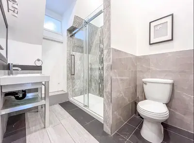 a bathroom with a toilet and a shower and a sink at Modern 2BR Haven - Prime Location in Montréal