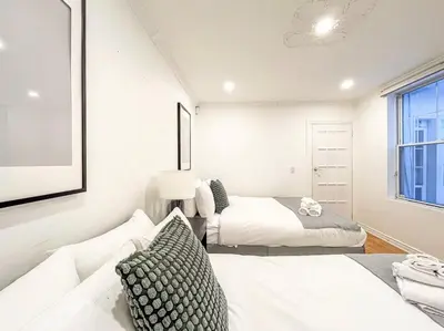 a white room with two beds and a couch at Luxury 3BR - Free Parking - Washer & Dryer in Montréal