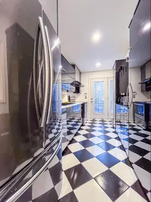 a kitchen with a refrigerator and a checkered floor at Luxury 3BR - Free Parking - Washer & Dryer in Montréal