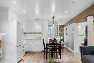 a kitchen and dining room with a table and chairs at Elegant 1BR Suite - Washer & Dryer - Prime Location in Montréal