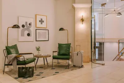 a living room with green chairs and a table at The Alexander Hotel - Old Montreal in Montréal