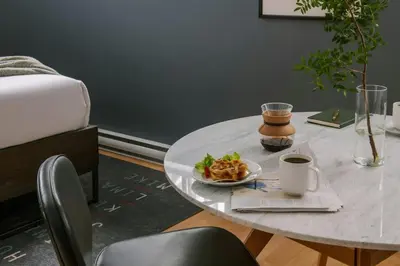 a table with a plate of food and a cup of coffee at The Alexander Hotel - Old Montreal in Montréal