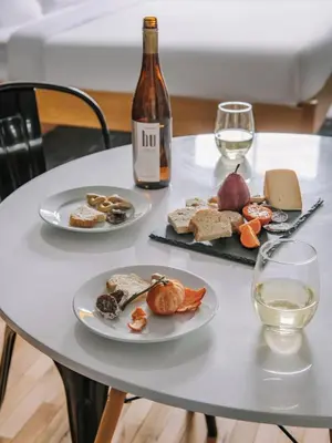 a table with two plates of food and a bottle of wine at The Alexander Hotel - Old Montreal in Montréal